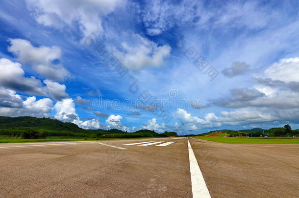 机场跑道出租车和白色的线条,绿色的山和蓝色天