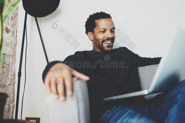 有魅力的有胡须的非洲的男人笑的和佃户租种的土地便携式电脑向St.KittsNevis圣基<strong>茨</strong>和尼维斯