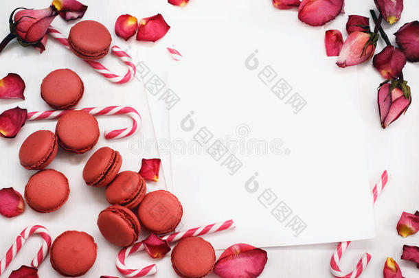 白色的背景和花瓣关于红色的玫瑰,马卡龙和焦糖