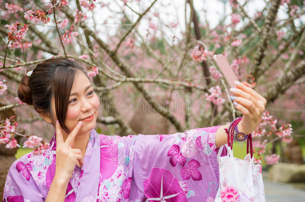 亚洲人女孩迷人的自拍照照片在樱花公园