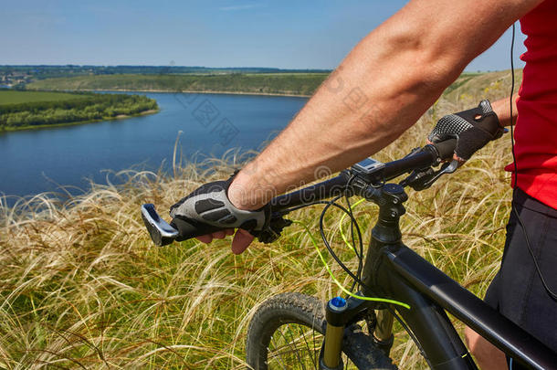 骑自行车的人旅行向山自行车通过绿色的草地反对比衣