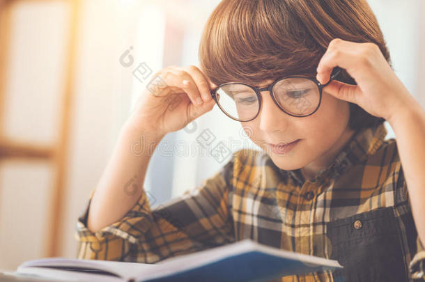 聪明的聪明的男孩固定他的眼镜