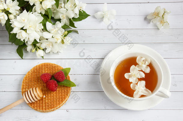 茶水杯子和茉莉花和薄的蛋奶烘饼和蜂蜜和地岬