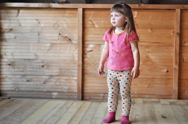 小的小孩女孩向木制的背景