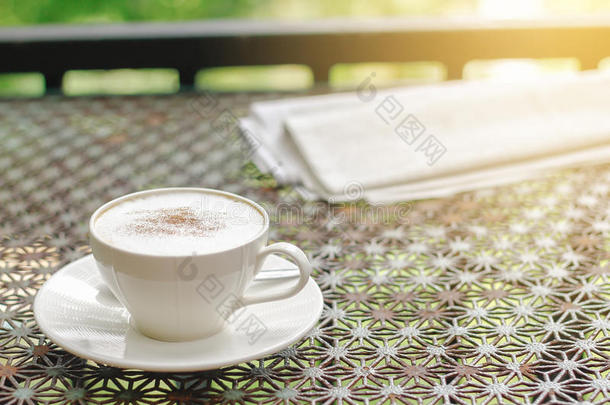 股份照片:卡普契诺咖啡咖啡豆和报纸向酿酒的表