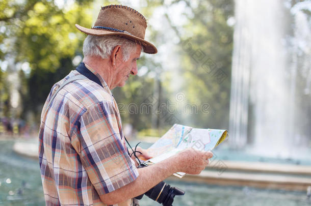 较高的旅行者男人搜索的为目的向地图