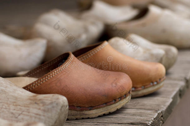 皮鞋子处在中各种各样的木制的鞋子向一木制的甲板.