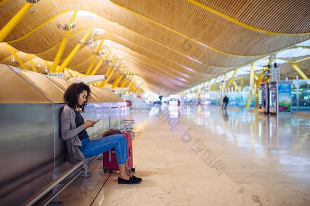 幸福的年幼的女人收听的音乐和耳机和可移动的photographer摄影师