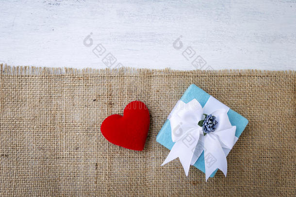 蓝色赠品盒和红色的心向粗麻布织物