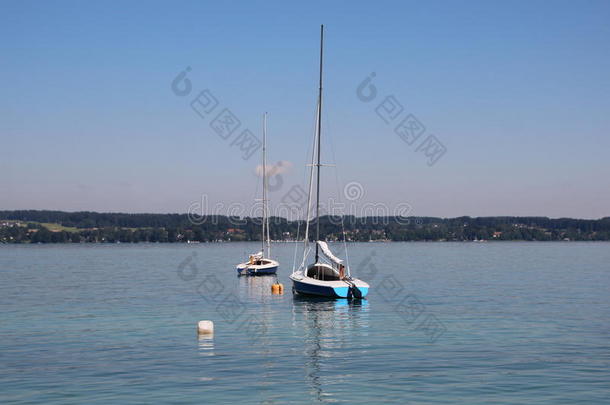 两个帆船运动小船向蓝色湖和山背景