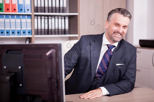 微笑的成熟的ChiefExecutiveOfficer执行总裁在他的书桌采用办公室