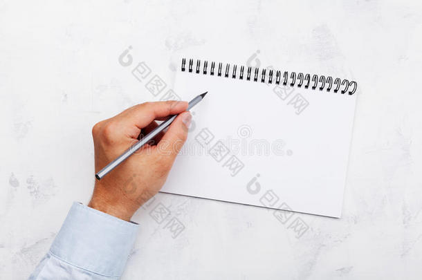 左撇子写采用空的笔记簿向白色的表顶看法.international国际的