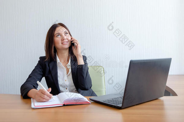商业女人和笔记簿,日历和可移动的电话在使工作.