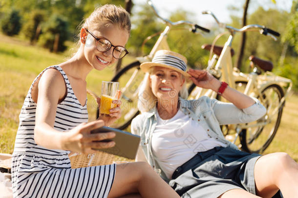 积极的祖母和十几岁的青少年女孩享有野餐郊游在户外