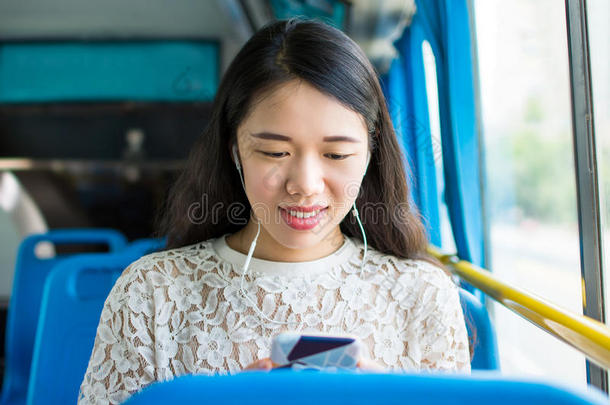 女孩收听的向音乐向一公众的公共汽车