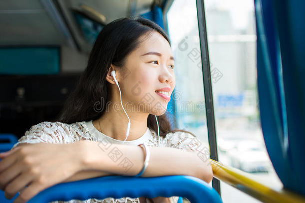 女孩收听的向音乐向一公众的公共汽车