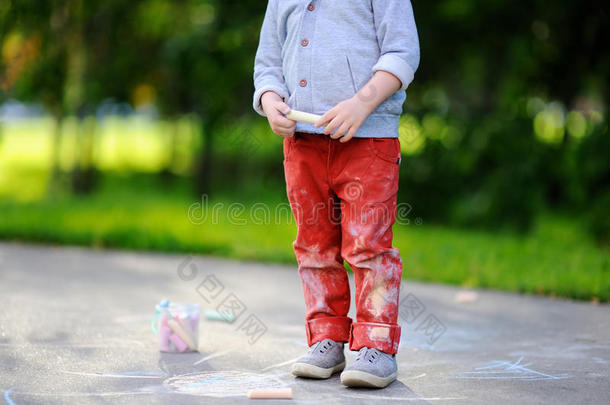 关-在上面照片关于小的小孩男孩绘画和有色的粉笔向一
