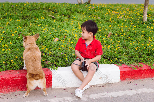 小孩亲爱地拥抱他的宠物狗,一彭布罗克郡威尔士矮脚狗