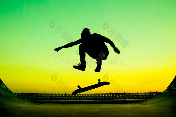 年幼的滑板运动员做指已提到的人戏法向一明亮的绿色的b一ckground
