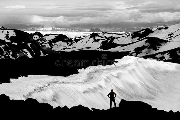 男人到达山顶点,观察冰河和雪原我