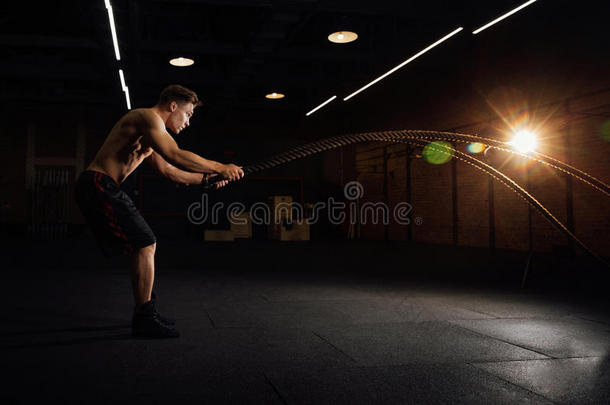 健康男人锻炼和与作战栏索在健身房.训练练习