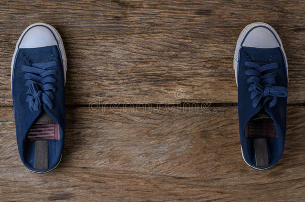 蓝色帆布鞋子向木制的背景和复制品空间.