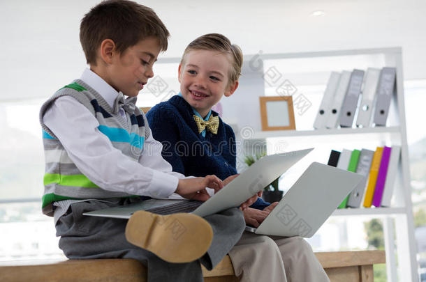 小孩同样地商业经理使用便携式电脑在期间一次向表