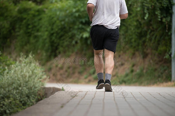 关-在上面男人跑步在户外令人难于忍受的重量损失