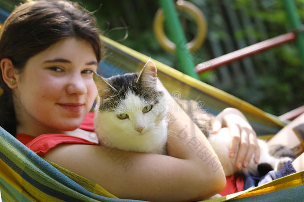 十几岁的青少年女孩采用吊床和猫关在上面夏照片