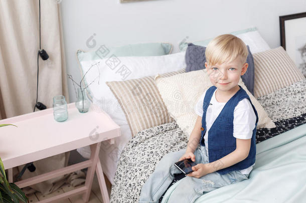 聪明的小的男孩和可移动的电话,席位向床采用床room.技术