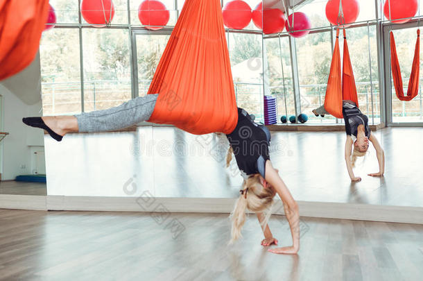 飞瑜伽.年幼的女人练习反对者-重力瑜伽和吊床.