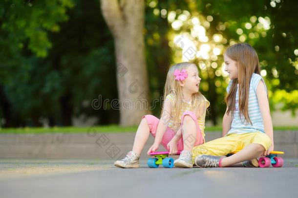 两个漂亮的小的女儿学问向滑板向美丽的summarization摘要