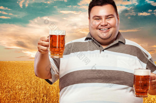 年幼的肥的男人在啤酒节,喝饮料啤酒向黄色的背景