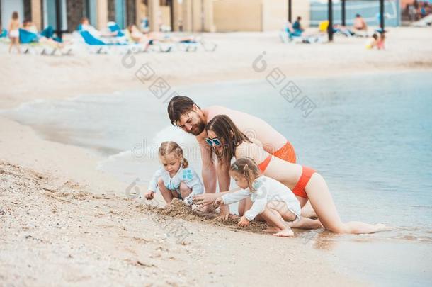 家庭假期双亲和孩子们向指已提到的人海岸夏一天