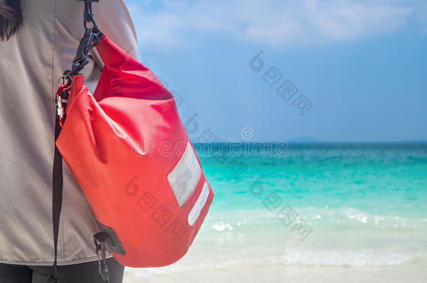 女人悬挂干的干燥的包装防水行李向指已提到的人海滩