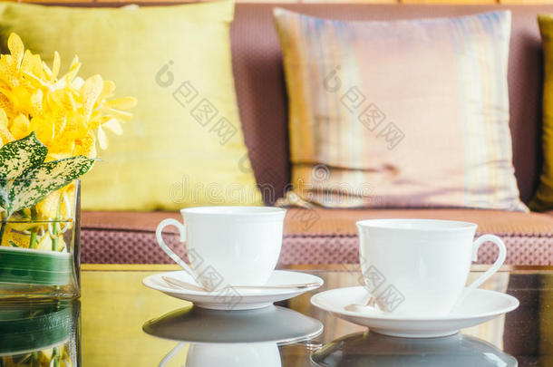 装饰瓶花和白色的咖啡豆杯子向表和枕头向沙发