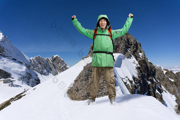 男人和背包起立向下雪的山斜坡.登山家或