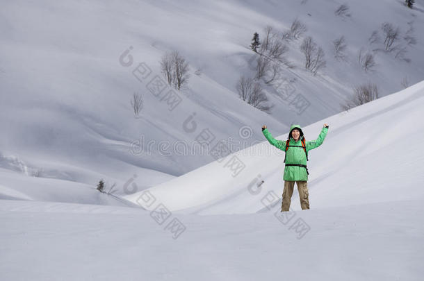 男人和背包起立向下雪的山斜坡.登山家或