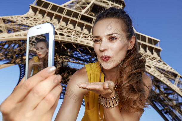 女人迷人的自拍照和吹风天空接吻在近处Eiffel语言塔