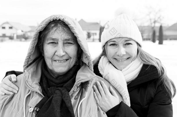 微笑的上了年纪的女人和年幼的照料者