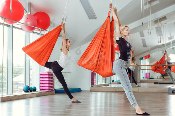 飞瑜伽.两个女人练习反对者-重力瑜伽和<strong>吊床</strong>.