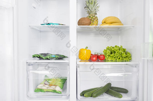 敞开的电冰箱满的关于新鲜的成果和蔬菜