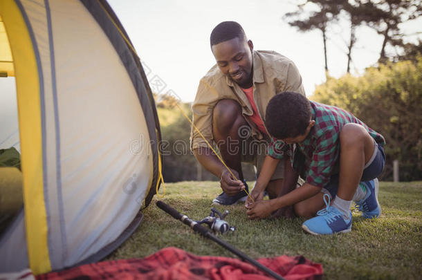 父亲和儿子是镶嵌在上面帐篷采用公园