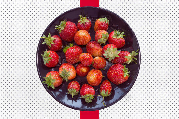 成熟的草莓采用黑的盘子