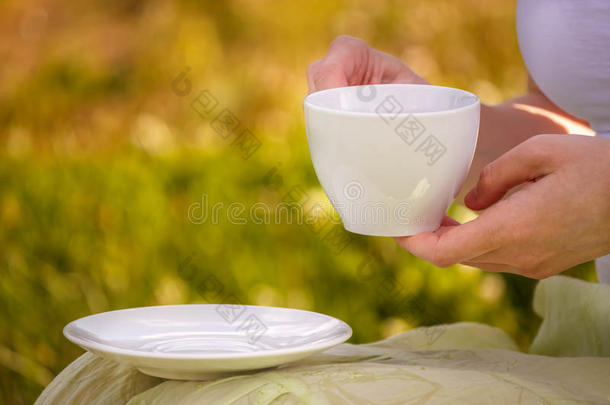 杯子关于黑的茶水采用指已提到的人手关于一年幼的女孩向野餐郊游