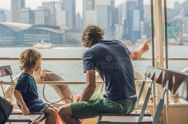 父亲和儿子游泳在旁边渡船通过四轮折篷马车海港采用商行戈恩