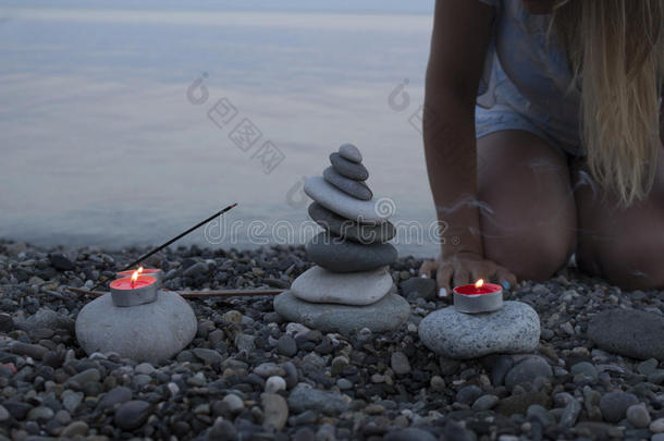 海卵石塔向指已提到的人海滩在日落,和蜡烛关在上面.
