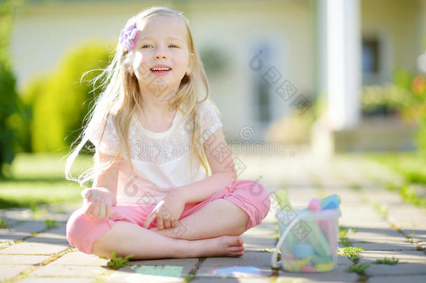 漂亮的小的女孩绘画和富有色彩的制造白色或彩色粉笔的白垩向一sidew一lk.总数