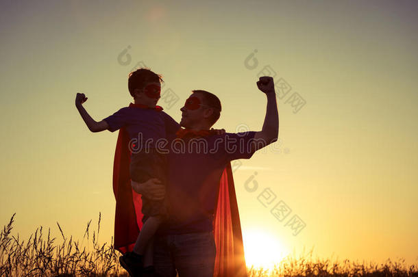 父亲和儿子演奏超级英雄在指已提到的人日落时间.