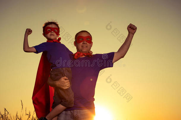 父亲和儿子演奏超级英雄在指已提到的人日落时间.